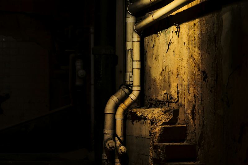 Basement with pipes and a small window at ground level