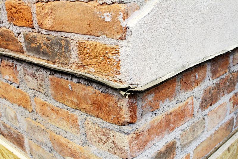 Black horizontal damp barrier membrane inserted into a brick wall